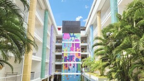 A multi-story hotel with a central atrium, balconies, and palm trees. - Viva Dash Hotel Seminyak (Keroboken Kelod)