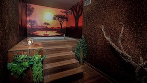 Un área de spa con una escalera de madera, un mural en la pared y una planta pequeña.