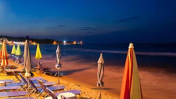 Aan het strand, ligstoelen aan het strand, parasols, een strandbar