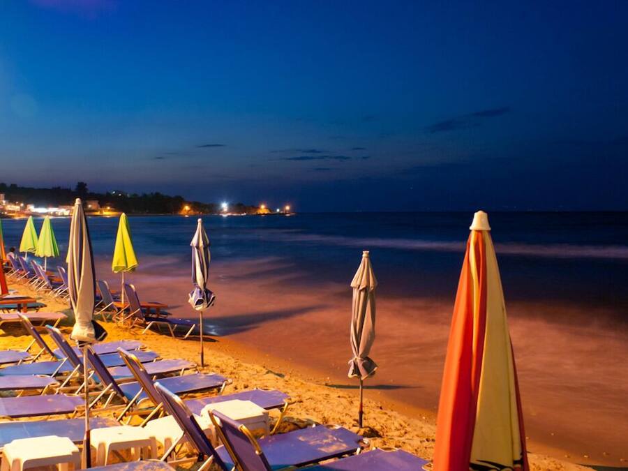 Na praia, espreguiçadeiras, guarda-sóis, bar na praia