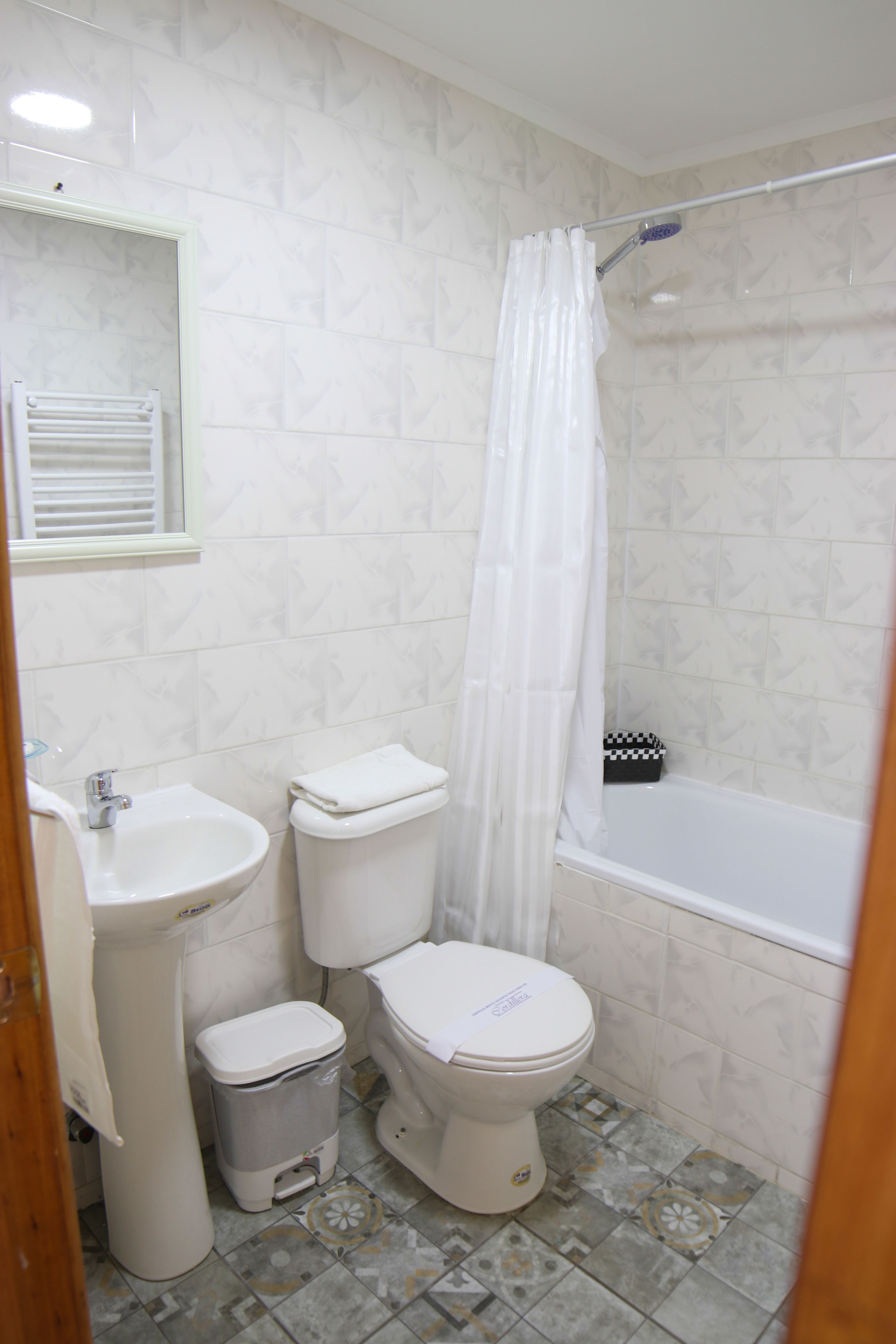 Un baño con inodoro, bidé, lavamanos y bañera.