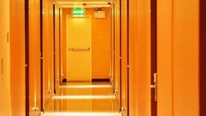 Ein Hotelgang mit Holztüren und Fliesenboden.