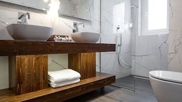 Ein modernes Badezimmer mit einem Holzbadezimmer, zwei Waschtüben, einem großen Spiegel und einer begehbaren Dusche.