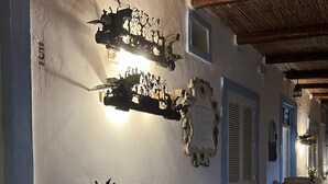 A cozy room with a wooden bench, a potted plant, and decorative wall art. - La Giara Vulcano (Lipari)