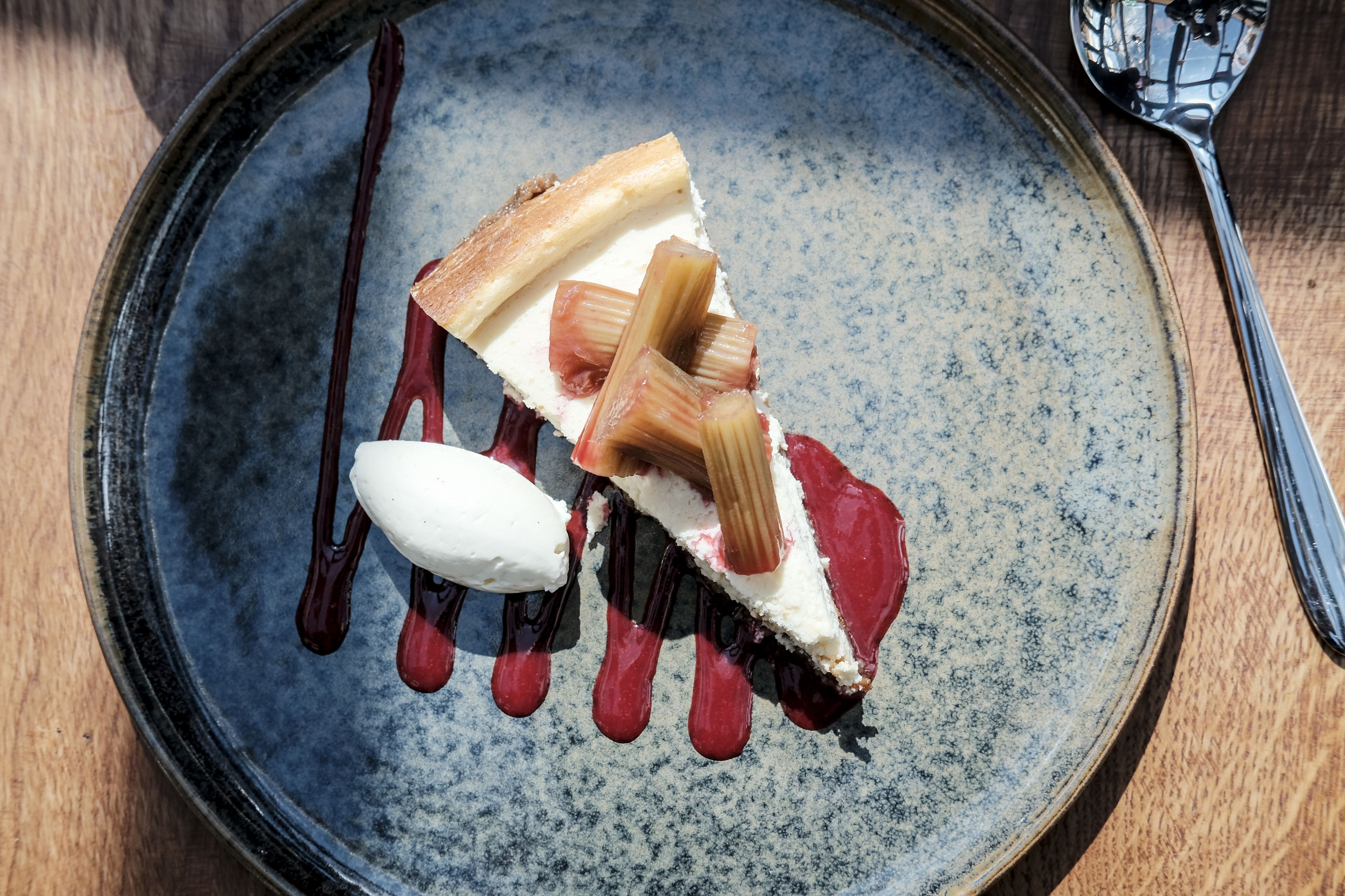 A dessert on a ceramic plate with a spoon.