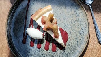 A dessert on a ceramic plate with a spoon.
