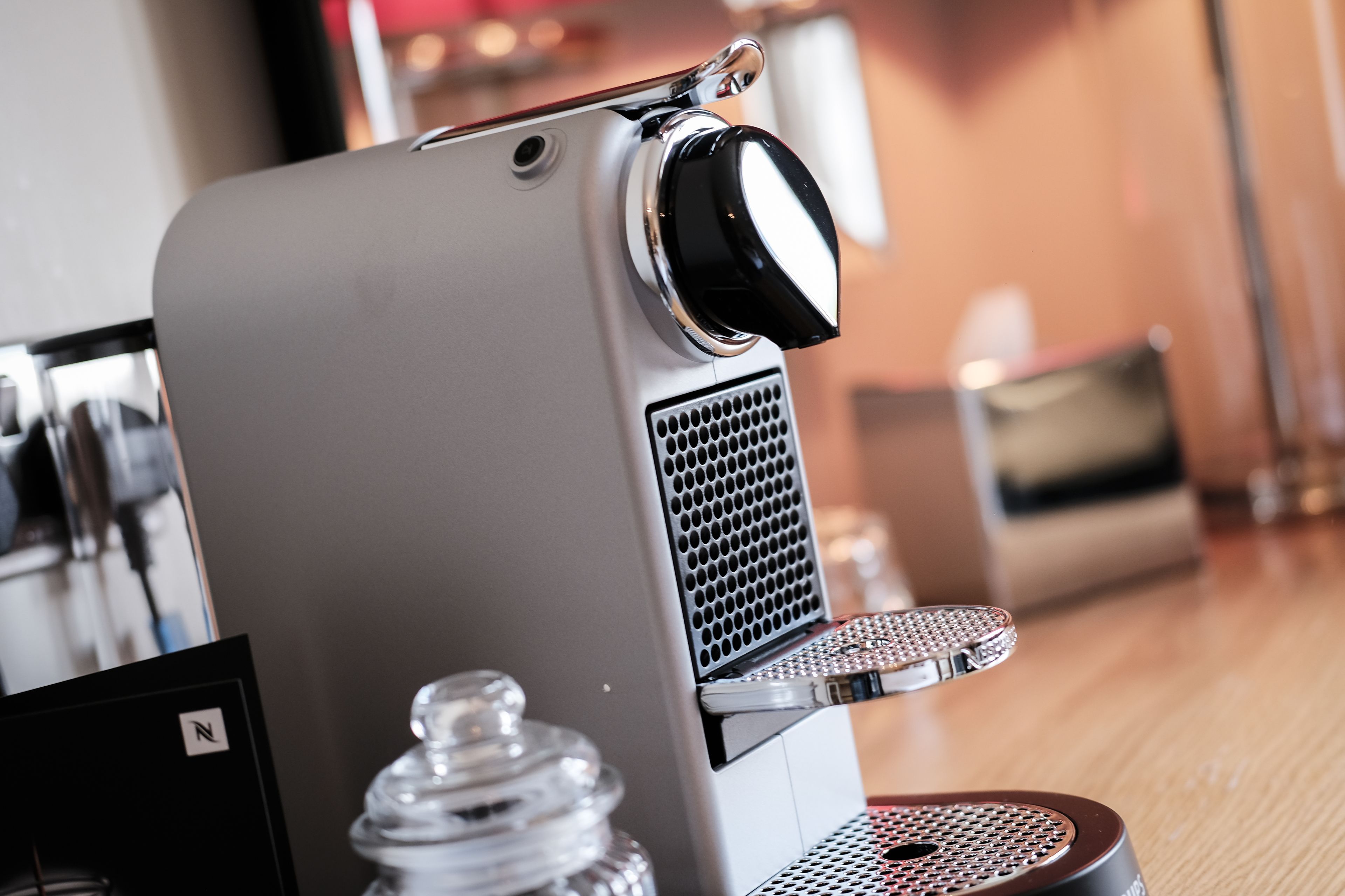 A coffee machine with a control knob, a water reservoir, and a drip tray.