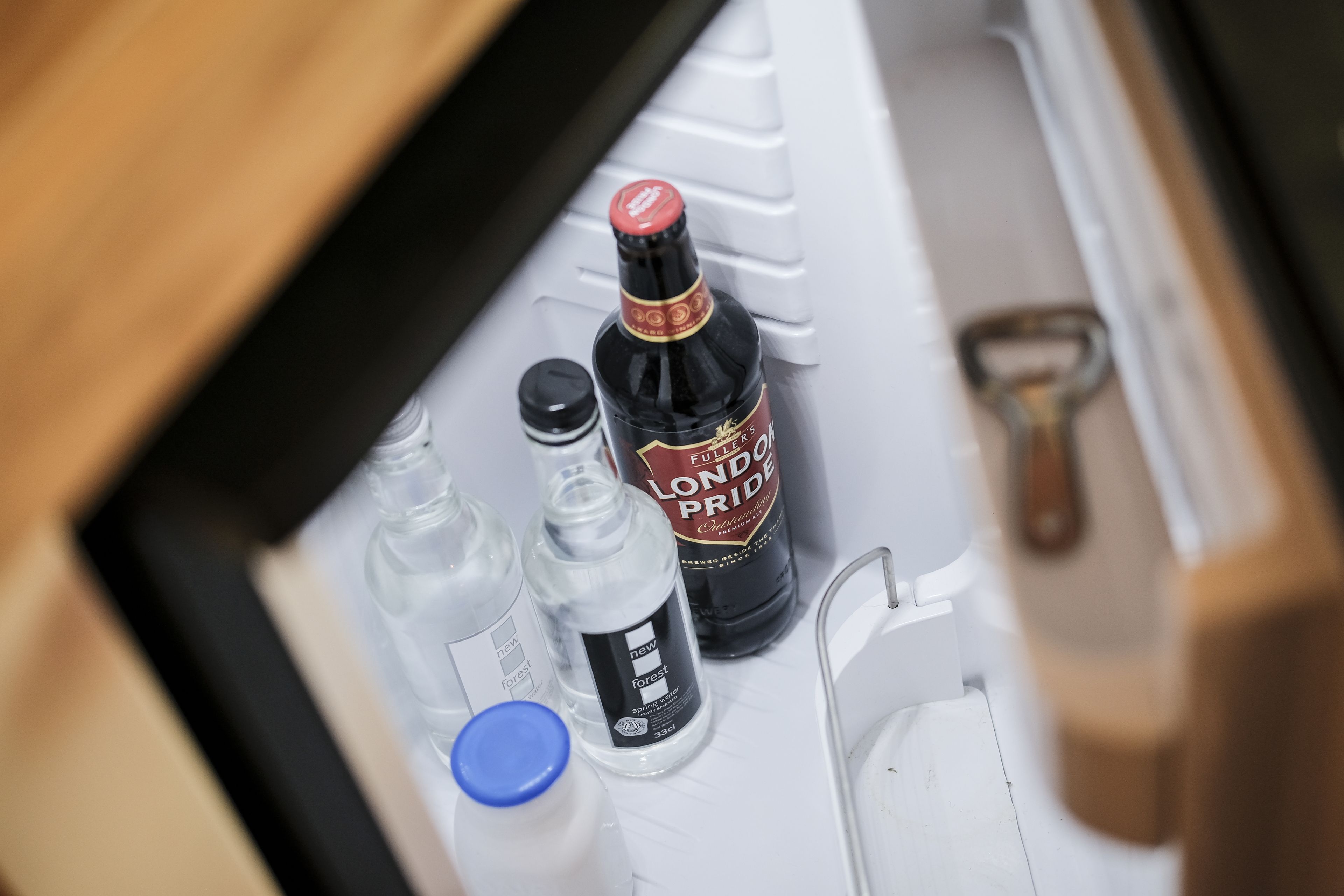 Die Mittelkonsole eines Autos mit einer Flasche London Pride, einer Flasche Forest und einer Flasche mit blauem Verschluss.