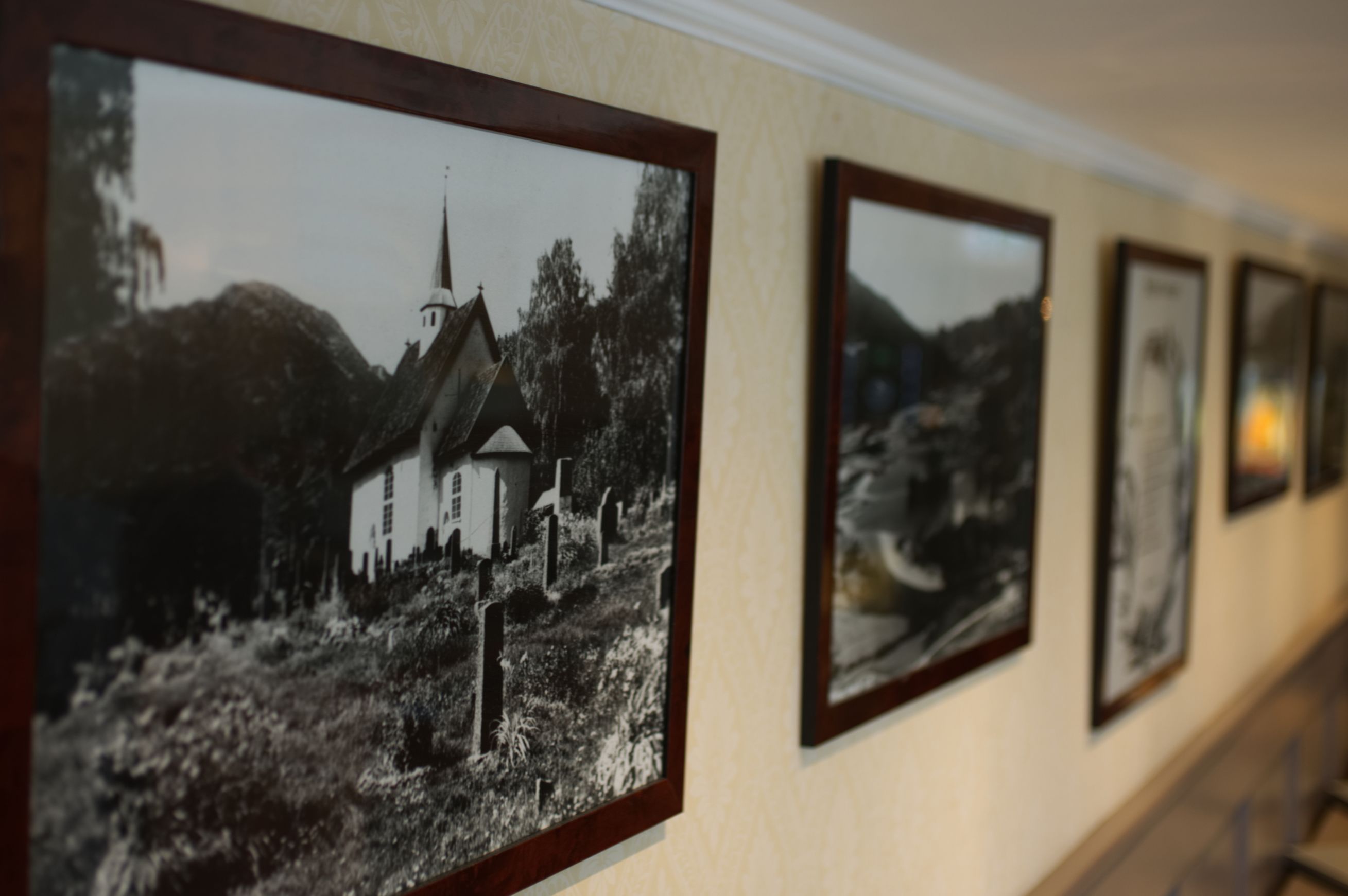 Un pasillo decorado con fotografías blanco y negro enmarcadas en la pared.