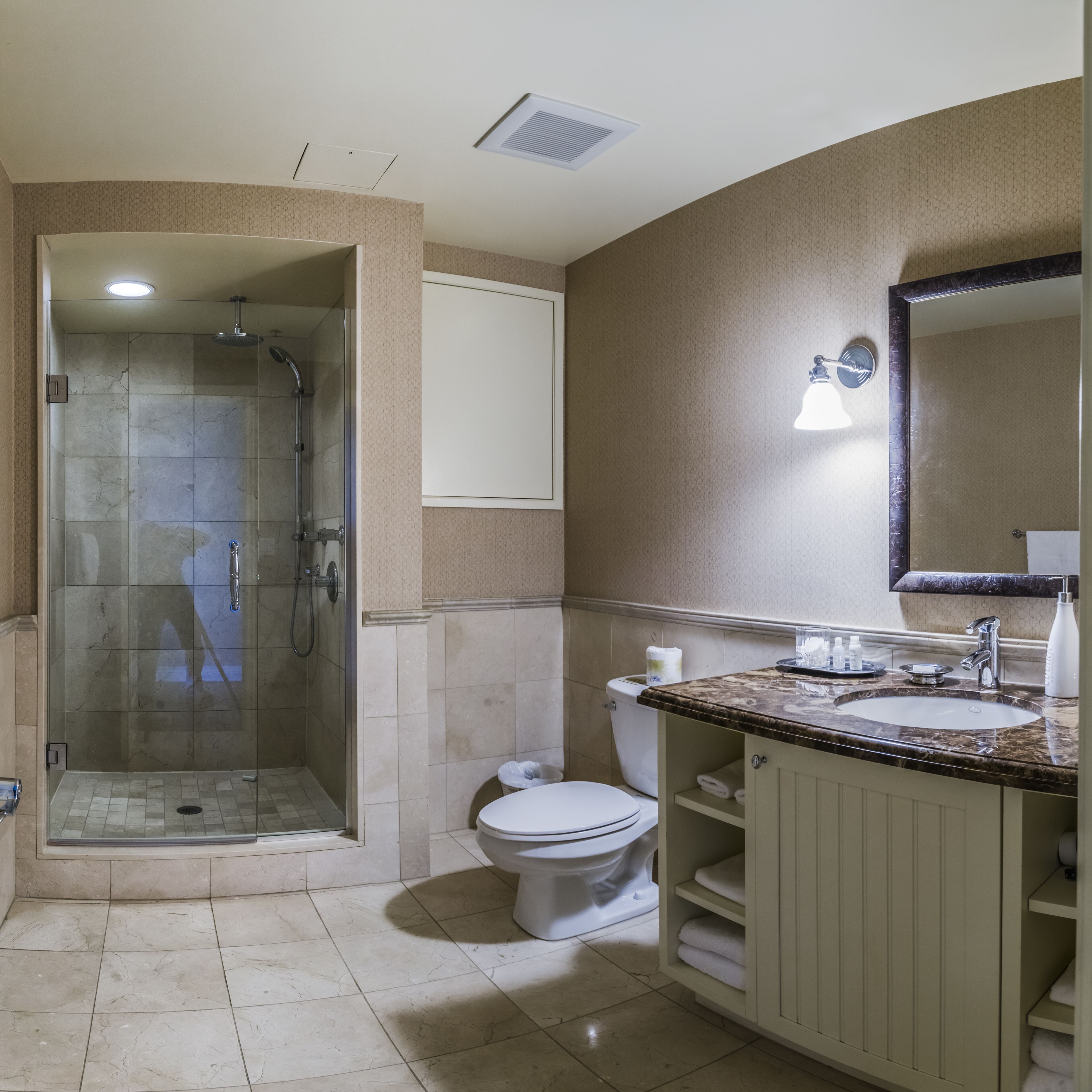 A bathroom with a shower, toilet, and sink.