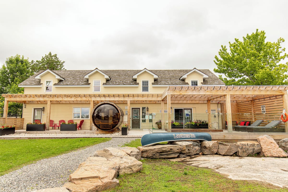 A two-story building with a covered patio area, outdoor seating, and a large decorative water feature.