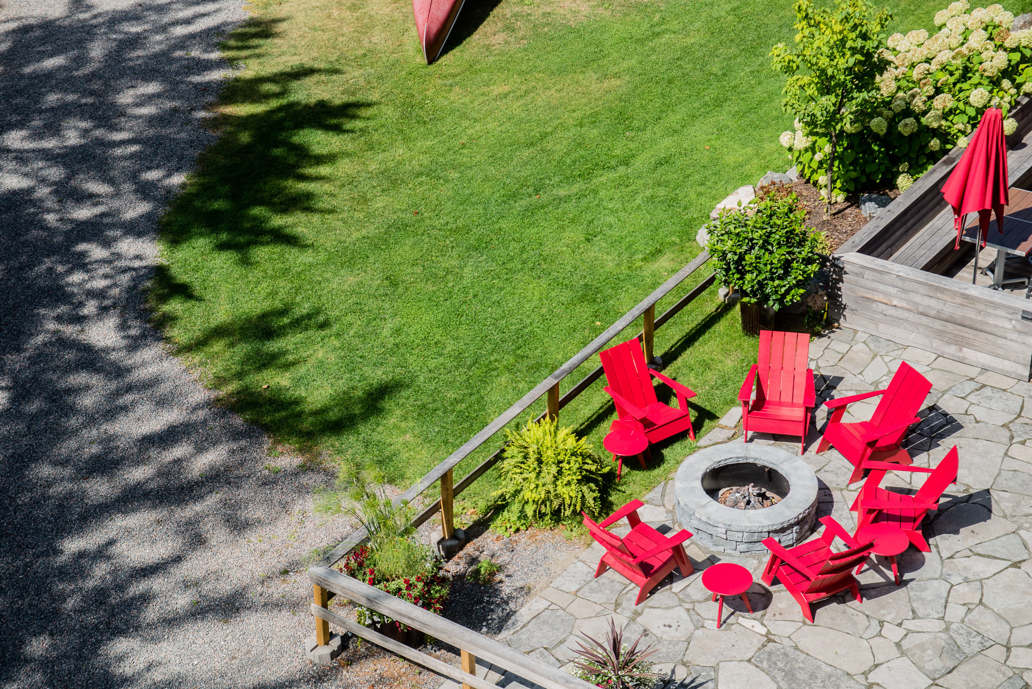 A patio area with red chairs and a fire pit.