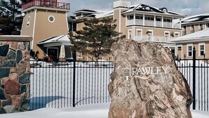 Un paisaje nevado con una roca grande que muestra el texto "RAWLEY Resort".