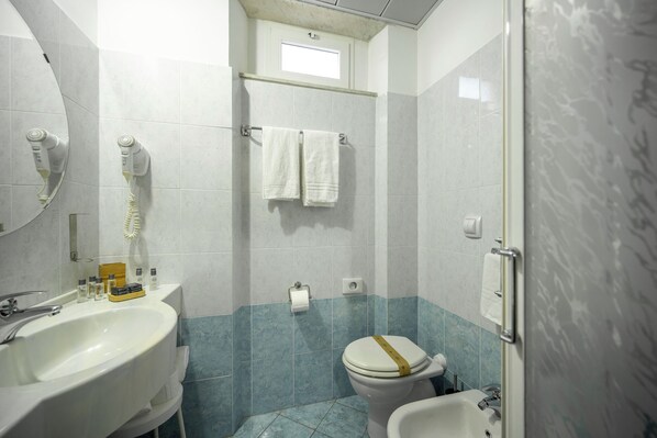 A bathroom with a sink, toilet, bidet, and a towel rack. - Hotel Mediterraneo (Lavagna)