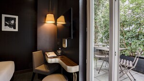 Une pièce moderne avec un mur foncé, un bureau en bois, une chaise et un téléviseur.