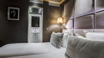 Una habitación de hotel con una cama grande, una lámpara de noche, un espejo y un cuadro en la pared.
