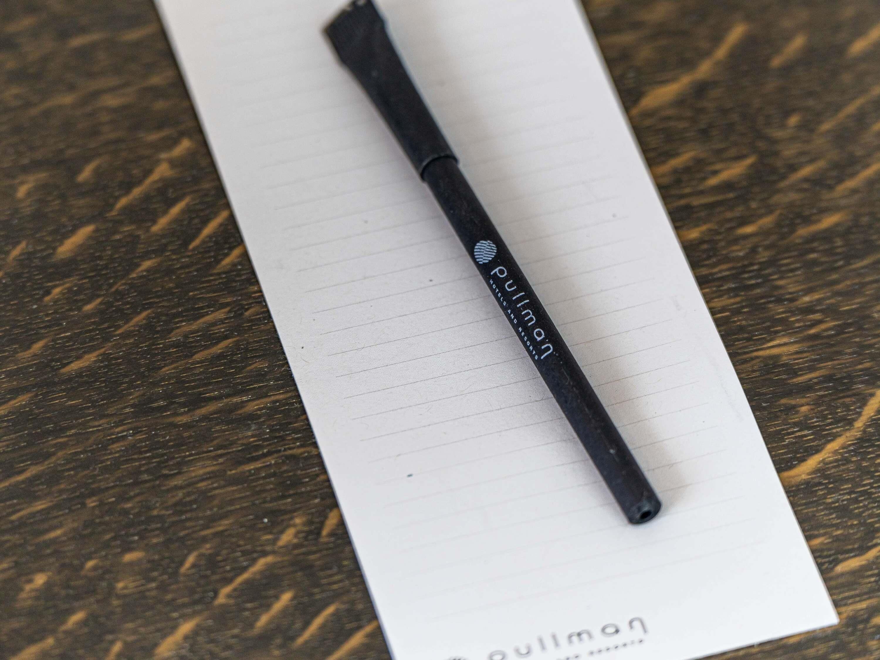 A black pen with the brand name 'Pulman' on a lined paper.