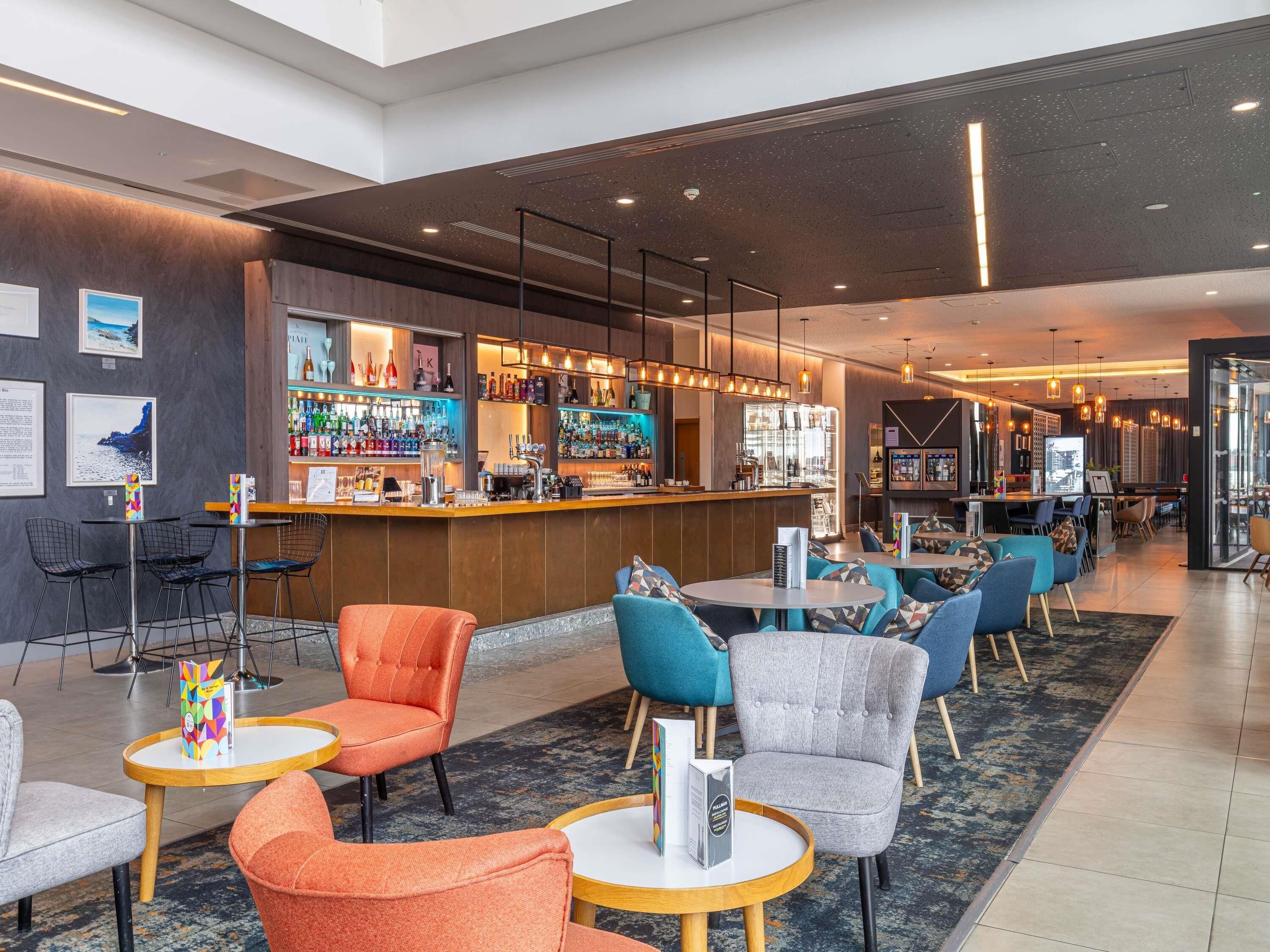 A modern bar area with seating and a bar counter.