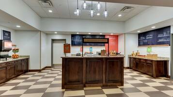 A bakery counter with a checkered floor, a sign that says "Happy Breakfast Starts Here," and a sign indicating the location of the bakery.