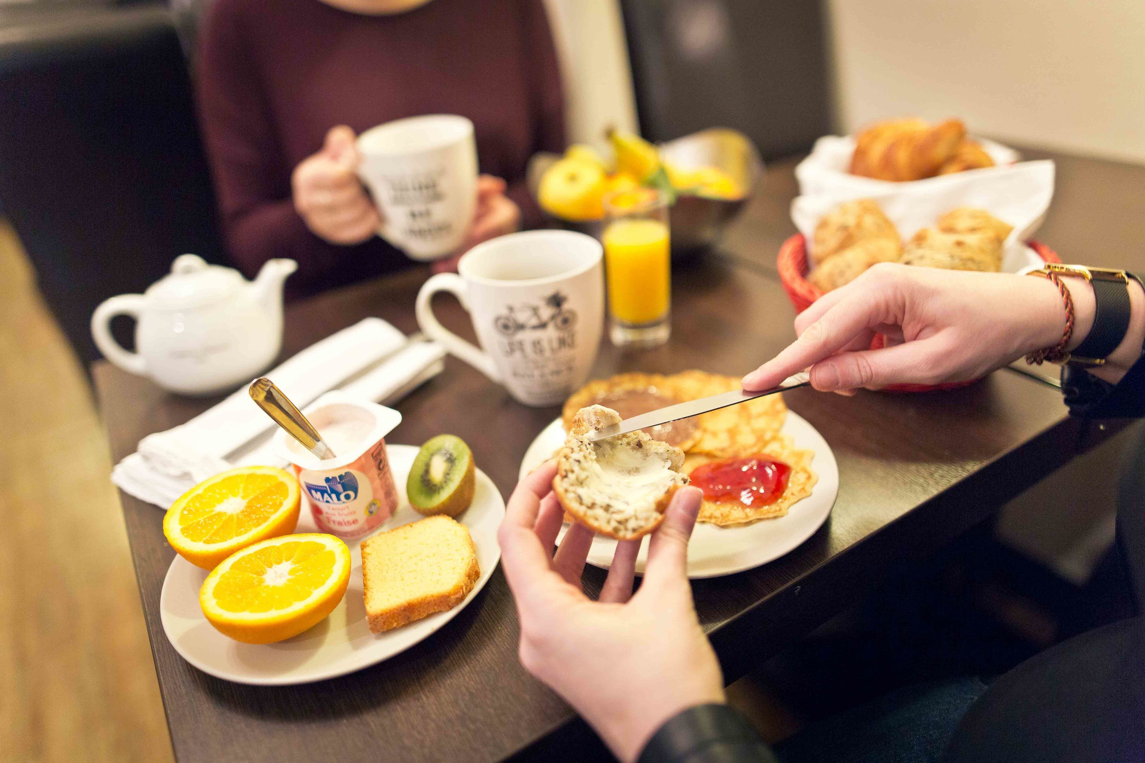 Una escena de desayuno con tostadas, rodajas de naranja y un pastel con mermelada.