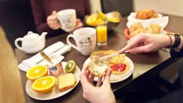 Una escena de desayuno con tostadas, rodajas de naranja y un pastel con mermelada.