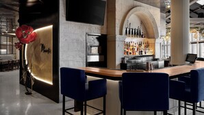 A modern bar area with a marble countertop, blue bar stools, and a wine display. - Hôtel MOCO Valleyfield (Salaberry De Valleyfield)