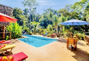 Una piscina al aire libre, sombrillas, tumbonas