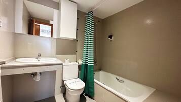 Un baño con lavamanos, inodoro y bañera.