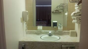A bathroom with a sink, mirror, towel rack, and a telephone.
