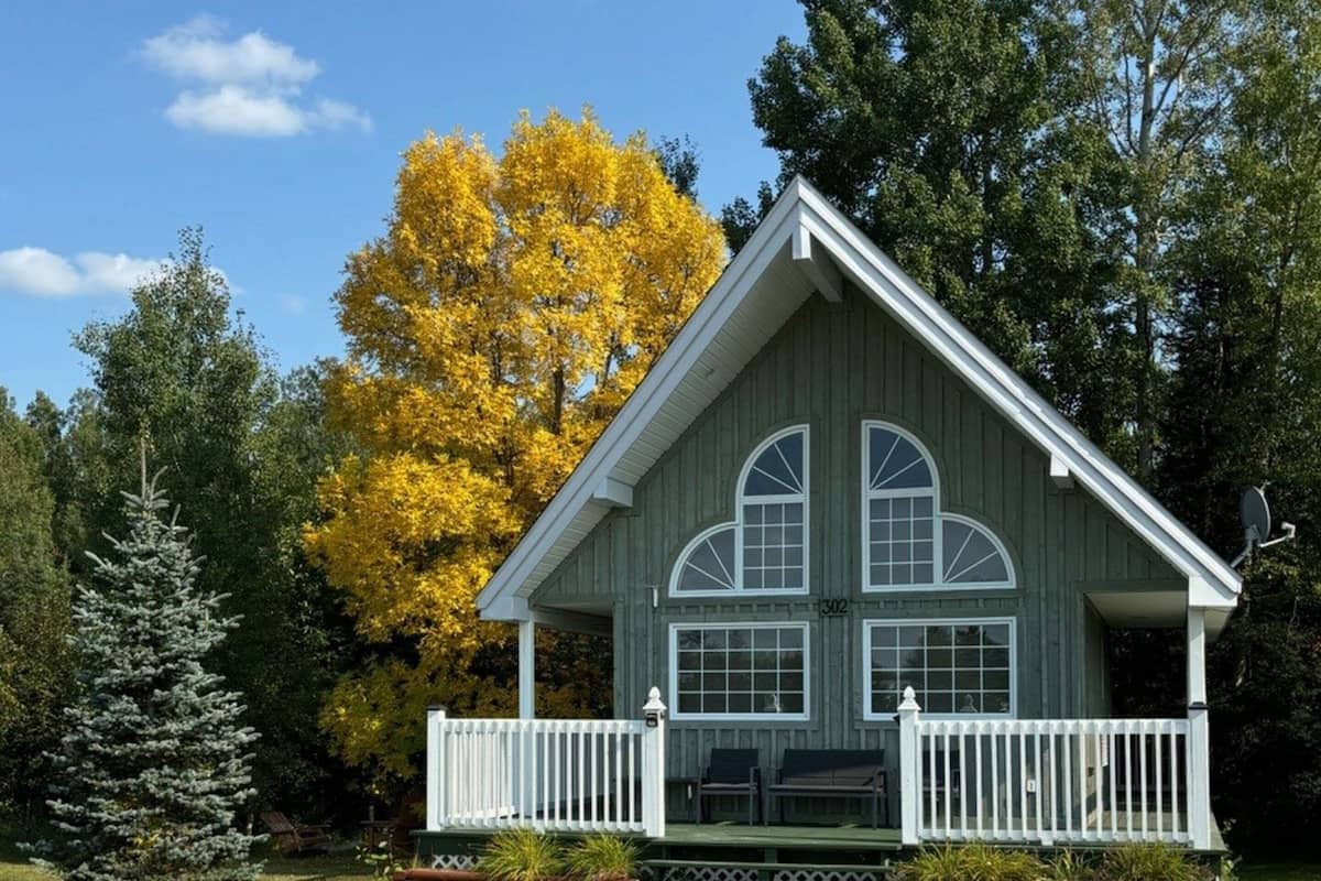 A small, single-story building with a gabled roof and a porch with white railings.