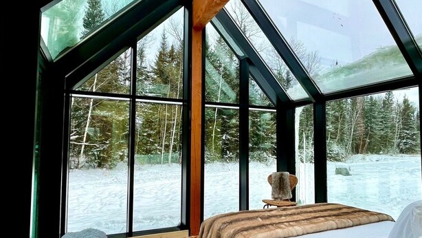 Una stanza con un letto, una finestra e vista su un paesaggio innevato.
