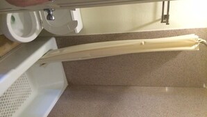 A bathroom with a toilet, sink, and a towel rack. - Bayshore Motel (La Porte)