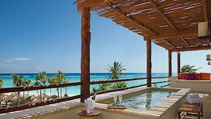 A poolside area with a view of the ocean, wooden pergola, and a small table with a bottle and glasses. - Secrets Akumal Riviera Maya - Adults Only - All Inclusive (Akumal)