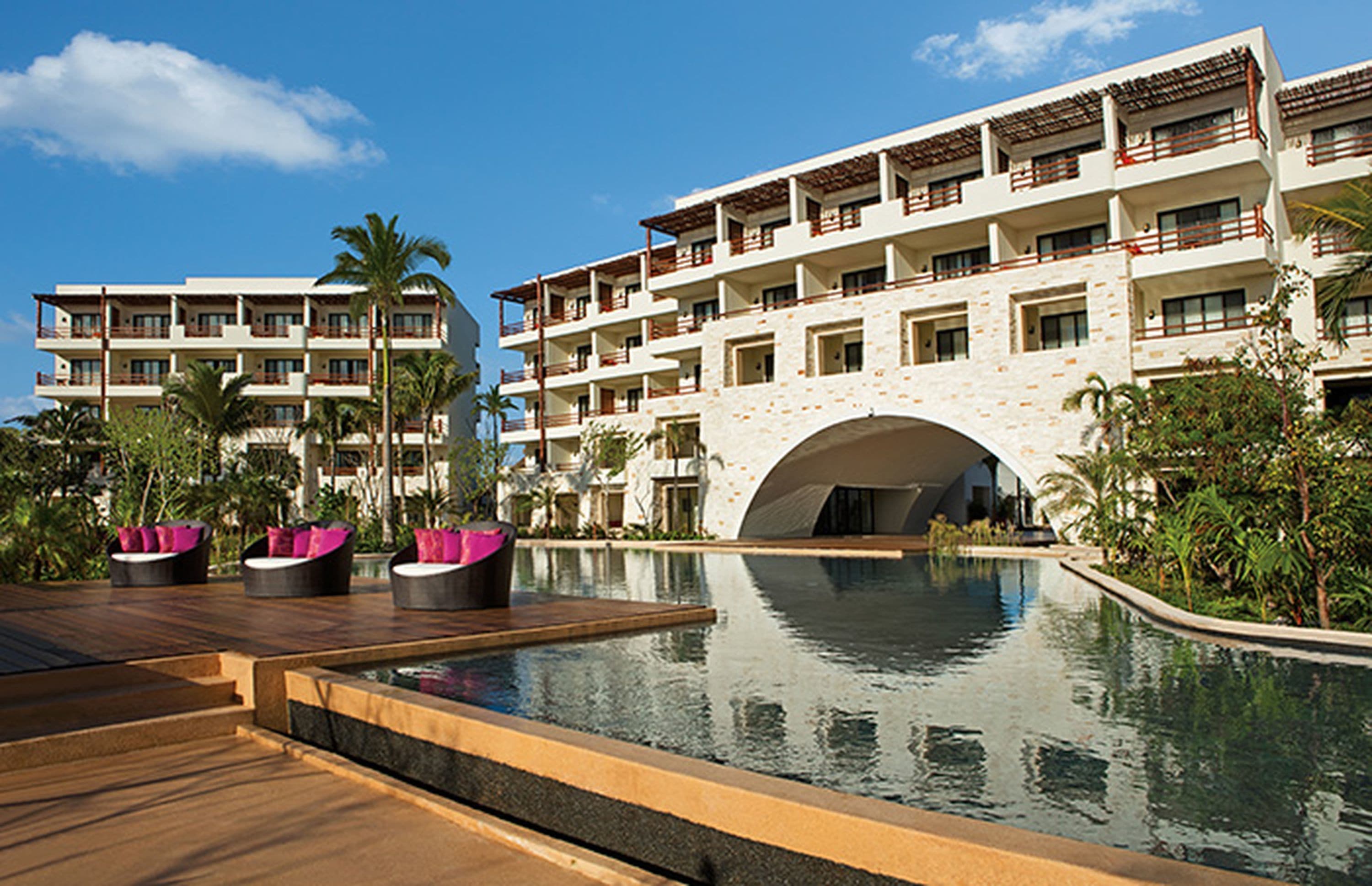 Un resort con piscina, varios balcones y fachada de piedra.