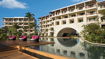 Un resort con piscina, varios balcones y fachada de piedra.