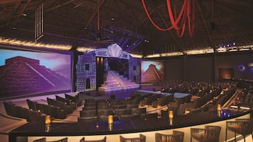 Un teatro con escenario, asientos y una zona de bar.