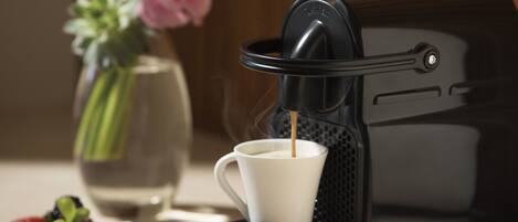 A Nespresso coffee machine with a cup of coffee being dispensed.