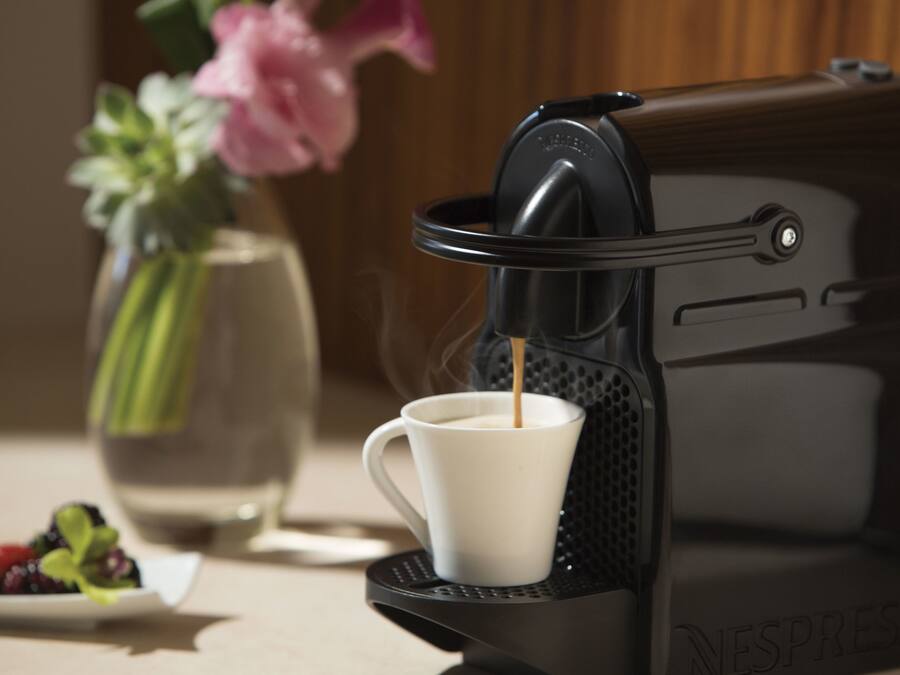 Una máquina de café Nespresso sirviendo una taza.