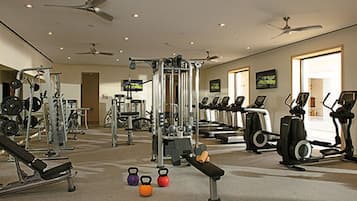 A gym with various exercise equipment, including treadmills, weight machines, and free weights.