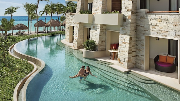 A resort with a swimming pool, palm trees, and a view of the ocean. - Secrets Akumal Riviera Maya - Adults Only - All Inclusive (Akumal)