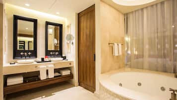 Une salle de bain moderne avec une grande baignoire, deux vasques et une porte en bois.