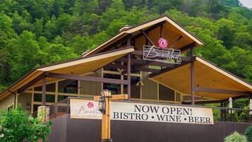 A restaurant with a sign indicating it is now open, offering a bistro, wine, and beer.