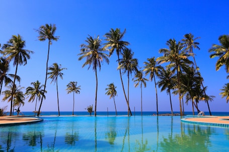 Una piscina al aire libre, sillones reclinables de piscina