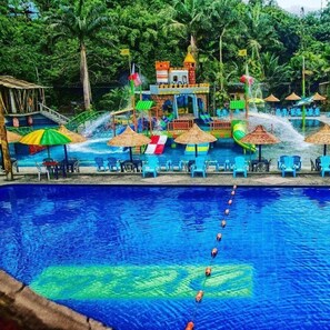 A swimming pool with a water slide and a play area. - Hostería D'Carlos (Santo Domingo de los Colorados)