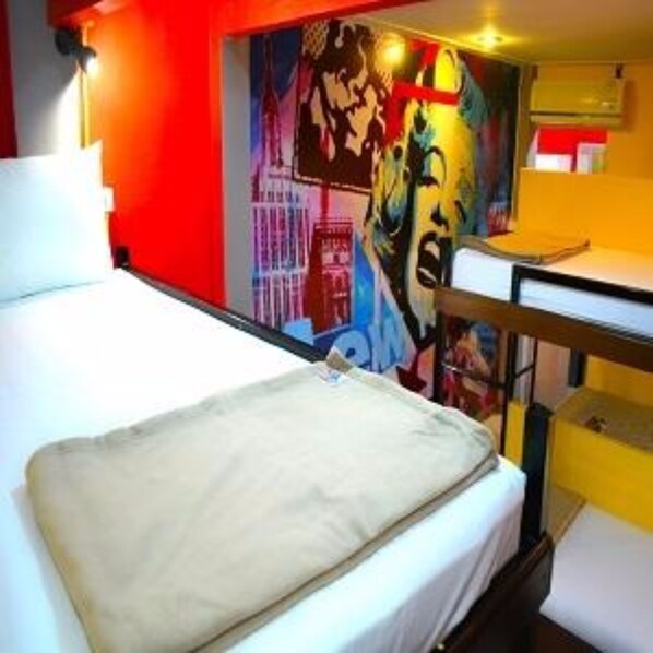 A hotel room with a bed, a desk, and a colorful mural on the wall. - Baan Talay Guesthouse & Dormitory (Ko Pha-ngan)