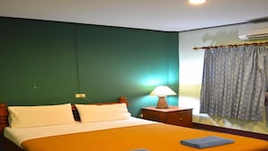 A hotel room with a large bed, a nightstand with a lamp, and a window with curtains. - Baan Talay Guesthouse & Dormitory (Ko Pha-ngan)