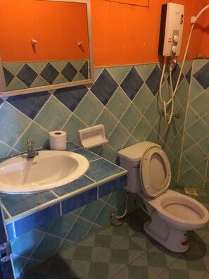 Ein Badezimmer mit Waschbecken, Toilette und einem Händetrockner.