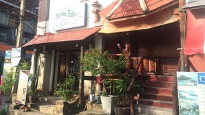 A traditional building with a signboard for a restaurant. - Baan Talay Guesthouse & Dormitory (Ko Pha-ngan)