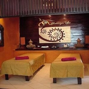 Un cuarto de spa con dos camas, una pared de madera y un panel decorativo.