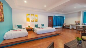 A hotel room with two beds, a desk, and a seating area. - Aukotan Place Hotel (Koh Tao)